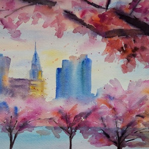 以下が含まれることがあります： 水彩画は、ピンクの桜の木が前景にあり、街の景色を描いています。街の建物は青と紫の色合いで描かれており、桜の花は鮮やかなピンクです。空は柔らかな青で、黄色のヒントがあります。