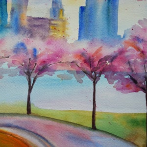 以下が含まれることがあります： 水彩画で描かれた街並みの風景画。前景にはピンクの桜の木が描かれている。木はピンク、パープル、ホワイトの色合いで描かれており、背景には淡いブルーの空が広がっている。