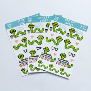 Peut inclure: Quatre feuilles d'autocollants sur le thème du ver de livre. Chaque feuille contient une variété d'autocollants représentant un ver vert portant des lunettes, tenant des livres et buvant du café. Le texte sur les feuilles indique "Book-Worm" et "Sticker Sheet".