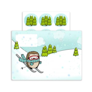 May include: A sheet of winter-themed stickers and a matching card. The card shows a cartoon hedgehog skiing down a snowy hill, wearing a blue scarf and goggles. The stickers feature a green tree design.