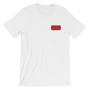 Op de afbeelding: Wit T-shirt met een rood ticketontwerp met de tekst "Valhalla R. Admit One".