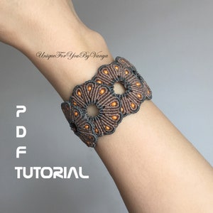 May include: A brown and grey macrame bracelet with orange beads. The bracelet is made using a knotting technique and features a circular design. The text "PDF TUTORIAL" is visible in the image.