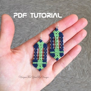 May include: A pair of green and blue macrame earrings with silver beads. The earrings are in the shape of a teardrop and are hanging from silver hooks. The earrings are on a hand, and the text "PDF TUTORIAL" is above the earrings.
