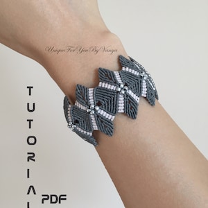 May include: Grey and pink macrame bracelet with silver beads. The bracelet is on a person's wrist. The text "TUTORIAL PDF" is on the left side of the image.