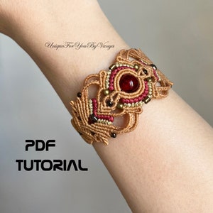 May include: A brown and red macrame bracelet with a red gemstone in the centre. The bracelet is on a person's wrist. The text "PDF TUTORIAL" is below the bracelet.
