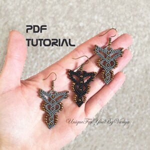 Pu&ograve; includere: Tre paia di orecchini fatti a mano con un design geometrico. Gli orecchini sono realizzati con filo nero, grigio e marrone e perline. Gli orecchini sono appesi a una mano.