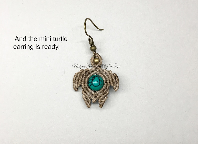 May include: A small, brown, knotted turtle earring with a turquoise stone in the center. The earring is attached to a gold hook.