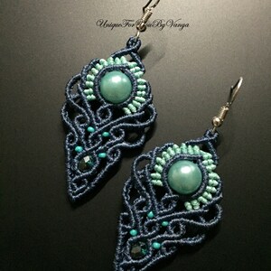 Pu&ograve; includere: Un paio di orecchini blu scuro e turchese con un design annodato e una perla rotonda turchese al centro di ogni orecchino. Gli orecchini sono realizzati con una tecnica di macram&egrave; e hanno ganci d'argento.