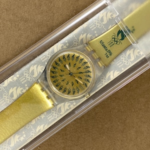 Reloj Swatch vintage: Juegos Olímpicos de Atlanta 1996, correa de plástico dorada, nuevo en caja