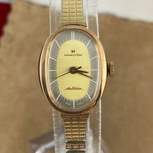 Vintage Uhr aus den 1970er Jahren. Hat ein Silber und Gold Farbe Zifferblatt weiße Zeiger Marker Erweiterungsarmband