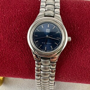 May include: A silver wristwatch with a blue face and a silver metal band. The watch face has silver hands and markers, and the word "Givenchy" is printed at the bottom.