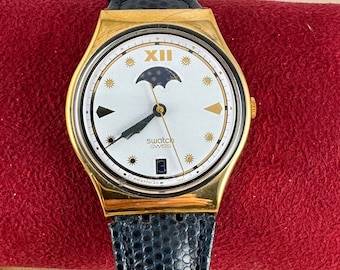 Rare Vintage New in Box Swatch Watch Moon Phase, Gold Plated Front Black Plastic Reverse , Navy Blue original 8.5 Inch Strap,