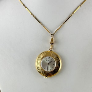 Vintage Bucherer 17 Jewel Swiss Pendant Watch 1 7/16 inch in diameter Black Hands and Accents with a Red Enamel and Gold Motifs on Reverse