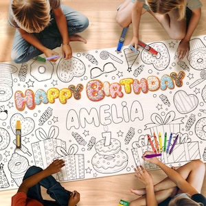May include: A large white coloring sheet with a birthday theme, featuring the words "Happy Birthday Amelia" and various illustrations of donuts, gifts, and sweets. Children are coloring the sheet with markers and crayons.