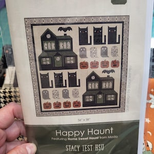 May include: A quilt pattern titled Happy Haunt by Stacy Iest Hsu, featuring a 56" x 58" design with black cats, ghosts, pumpkins, and haunted houses. The pattern includes the code SIH105 and text indicating it features Home Sweet Haunt from Moda.