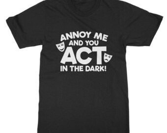 May include: Black t-shirt with white text that reads "Annoy me and you act in the dark!" with two white theatrical masks on either side of the word "act".