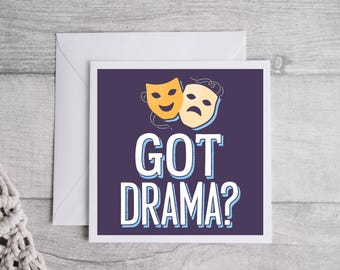 Op de afbeelding: Een paarse kaart met een witte rand en de tekst "GOT DRAMA?" in wit met een blauwe omtrek. Twee gele en oranje theatermaskers bevinden zich boven de tekst.