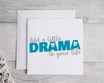 Op de afbeelding: Witte wenskaart met de tekst "Add a little DRAMA to your life" in teal en grijs. Het woord "DRAMA" bevat twee theatermaskers. Een envelop bevindt zich achter de kaart.