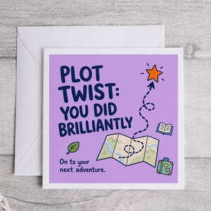May include: A square greeting card with a light purple background featuring the dark blue text PLOT TWIST: YOU DID BRILLIANTLY and On to your next adventure. Graphics include an orange star, a dotted path, a map, a book, and a suitcase.