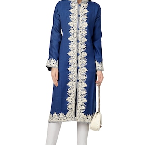 May include: A long, blue tunic with white embroidery. The tunic has a mandarin collar and a front zipper closure. The embroidery is a floral pattern that runs down the front of the tunic.