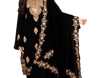 May include: Black velvet embroidered salwar kameez set. The set includes a long-sleeved tunic, matching pants, and a shawl. The tunic and pants feature intricate gold floral embroidery. The neckline and cuffs are also embellished with gold embroidery.
