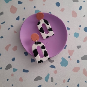 Cow print cut out arch dangle earrings made from polymer clay