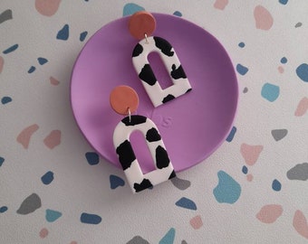 Cow print cut out arch dangle earrings made from polymer clay