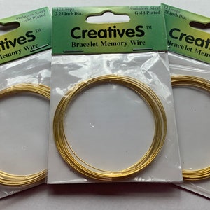 Peut inclure: Trois paquets de fil mémoire en acier inoxydable plaqué or pour la fabrication de bijoux. Chaque paquet contient 12 boucles de fil, avec un diamètre de 5,7 cm. Les paquets sont étiquetés "CreativeS Bracelet Memory Wire".