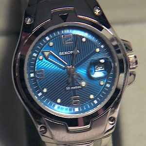 Reloj deportivo Sekonda para mujer: esfera azul agua, pulsera plateada, estilo buzo.