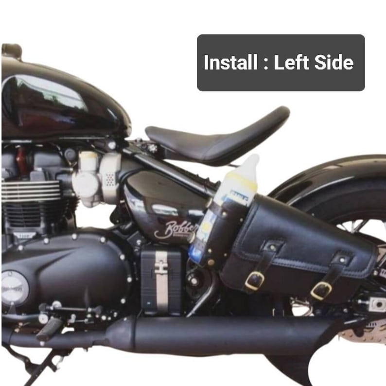 May include: Black leather motorcycle saddlebag with buckles, attached to a black motorcycle. The saddlebag is on the left side of the motorcycle. The text "Install: Left Side" is visible in the image.
