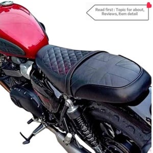 Puede incluir: Asiento de motocicleta de cuero negro con un patr&oacute;n acolchado y un dise&ntilde;o de Union Jack. El asiento est&aacute; montado en una motocicleta negra.