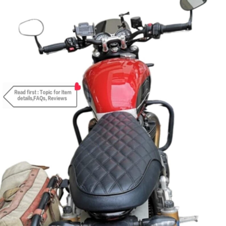 May include: A red motorcycle with a black quilted seat and a black handlebar. The motorcycle has a black windshield and a black rearview mirror. The motorcycle is parked on a white background.