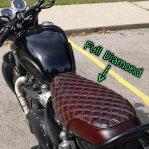 Puede incluir: Una motocicleta negra con un asiento de cuero marr&oacute;n con un patr&oacute;n de diamante. El asiento est&aacute; etiquetado como "Full Diamond".