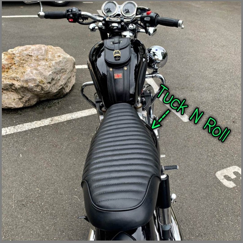 Puede incluir: Asiento de motocicleta negro con un dise&ntilde;o acolchado. El asiento est&aacute; unido a una motocicleta negra con una alforja de cuero negro. El texto "Tuck N Roll" est&aacute; escrito en la imagen.