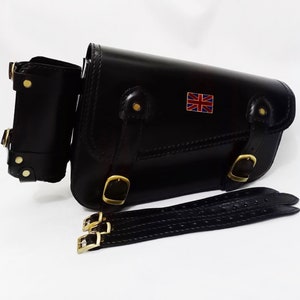 May include: Black leather motorcycle saddlebag with a Union Jack patch, a smaller pouch, and a black leather strap with buckles.