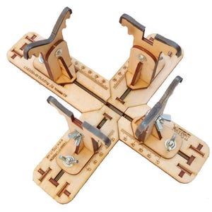Könnte beinhalten: Eine Holzvorrichtung mit vier verstellbaren Klemmen und Messmarkierungen. Die Vorrichtung besteht aus hellem Holz und hat Metallbeschläge. Der Text "LMOB-45 Building Jig" ist sichtbar. Die Vorrichtung scheint für die Holzbearbeitung oder das Kunsthandwerk bestimmt zu sein.