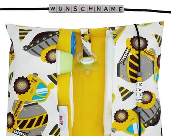 May include: A white and yellow diaper clutch with a black strap and a yellow zipper. The clutch has a print of yellow construction trucks on a white background. The clutch has two pockets on the inside, one for a diaper and one for wipes. The clutch also has a small pocket on the outside for a pacifier. The clutch is decorated with a name tag that says "NAME" in black letters. The clutch is also decorated with a name tag that says "WUNSCHNAME" in black letters.