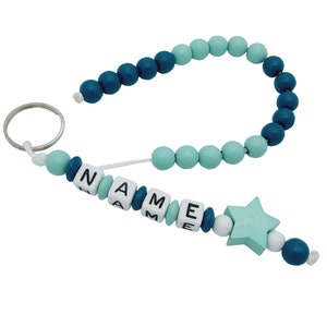 Könnte beinhalten: Ein blauer und grüner Perlen-Schlüsselanhänger mit einem Stern-Anhänger und dem Wort "NAME" in weißen Perlen.