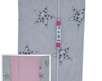 May include: A gray fabric photo album with a pink fabric lining and a white string with pink beads and white letter beads spelling "NAME". The album has a repeating pattern of gray stars on a white background.