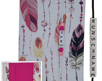 May include: A white fabric book cover with a pink and white feather pattern. The cover has a pink zipper and a pink beaded bookmark with the word "NAME" on it. The cover is attached to a black strap with white beads that spell "WUNSCHNAME".