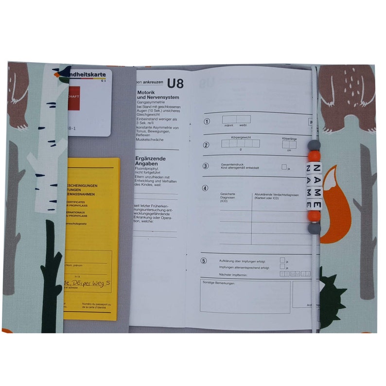 K&ouml;nnte beinhalten: Ein grauer und wei&szlig;er Stoffordner mit einem Fuchs- und B&auml;renmotiv. Der Ordner hat eine Tasche auf der Vorderseite und einen Bereich f&uuml;r eine Gesundheitskarte. Der Text "U8" ist auf der Vorderseite des Ordners gedruckt.
