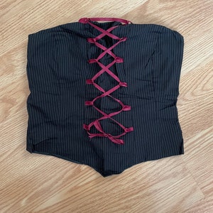 May include: A black and white striped strapless top with a red ribbon laced up the back.