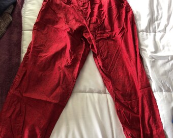 May include: Red pants with a drawstring waist and elastic cuffs. The pants have a subtle pattern.