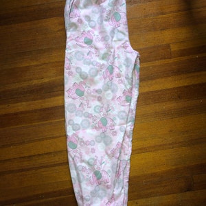 May include: Pink pyjama bottoms with a white background and a pattern of grey elephants and pink flowers.