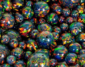 May include: A collection of iridescent, dark blue opal beads with vibrant flashes of color. The beads vary in size and have a polished, glossy finish. Each bead is drilled with a hole for stringing, perfect for jewelry making.
