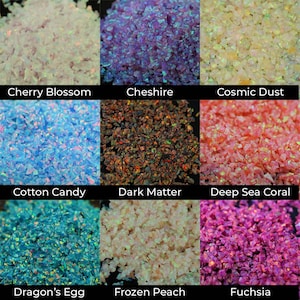 Puede incluir: Una colecci&oacute;n de piedras preciosas trituradas e iridiscentes en varios colores. La imagen muestra nueve colores diferentes, incluyendo Cherry Blossom, Cheshire, Cosmic Dust, Cotton Candy, Dark Matter, Deep Sea Coral, Dragon's Egg, Frozen Peach y Fuchsia.