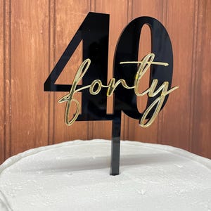 May include: Black acrylic cake topper with the number 40 and the word "forty" written in gold script.