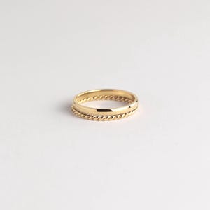 May include: A gold ring with a twisted band design.