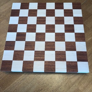 May include: A wooden chessboard with alternating dark brown and white squares.