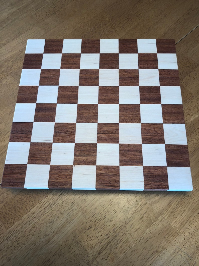 May include: A wooden chessboard with alternating dark brown and white squares.